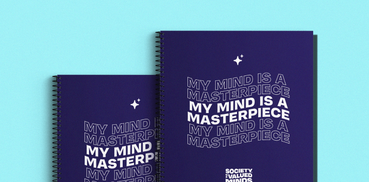 Two identical journals sit side by side. Thery have a blue cover with a sparkly icon and the repeated phrase "MY MIND IS A MASTERPIECE" above the Society of Valued Minds logo.